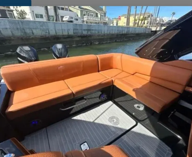Slide: The Image of 2021 Cruisers Yachts 338 SS with orange seating by the water. - 13