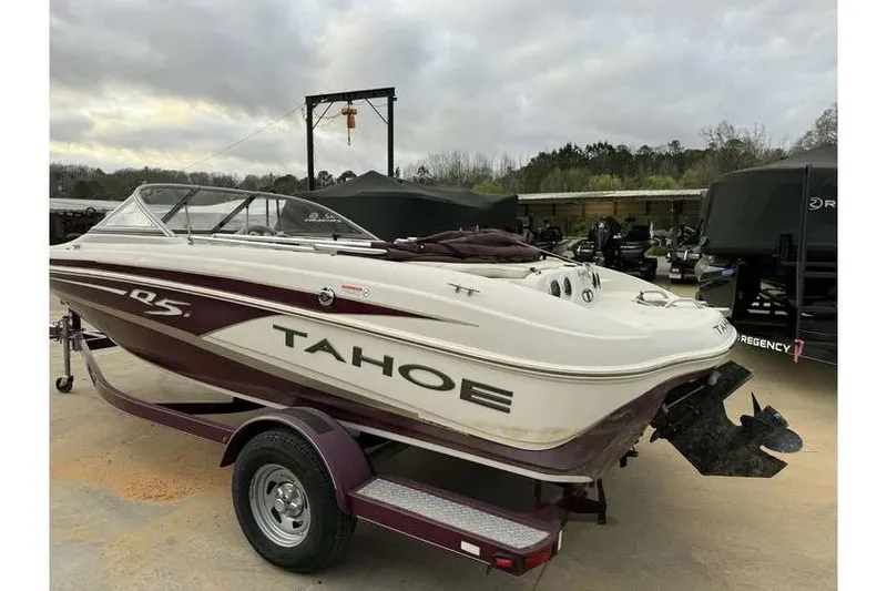 Slide: The Image of 2014 Tahoe Q5i SF boat on trailer, parked outdoors under cloudy sky. - 6