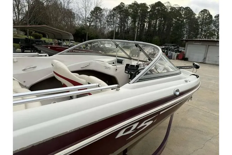 Slide: The Image of 2014 Tahoe Q5i SF boat with white and maroon design, parked outdoors. - 8