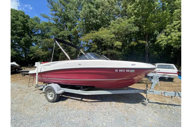Slide: The Image of 2016 Bayliner VR5 Bowrider OB on trailer, parked outdoors with trees in background. - 4