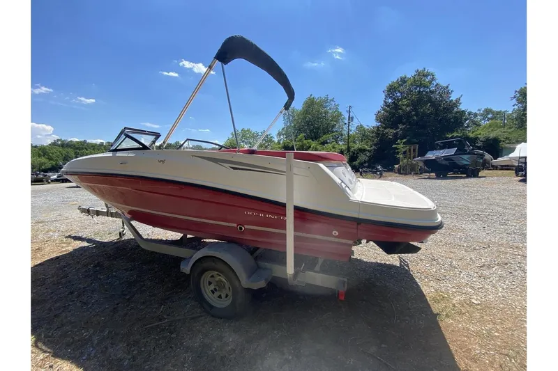 Slide: The Image of 2016 Bayliner VR5 Bowrider OB on trailer, red and white, parked outdoors under clear sky. - 7
