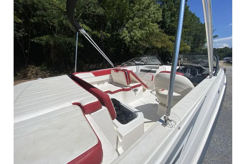 Slide: The Image of 2016 Bayliner VR5 Bowrider OB interior with red and white seating, parked outdoors. - 9
