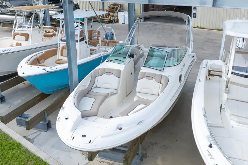 The Image of 2002 Sea Ray 270 Sundeck boat in storage, featuring spacious seating and sleek design. - 1