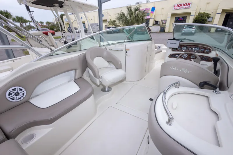 Slide: The Image of 2002 Sea Ray 270 Sundeck interior with beige seating and modern dashboard. - 12