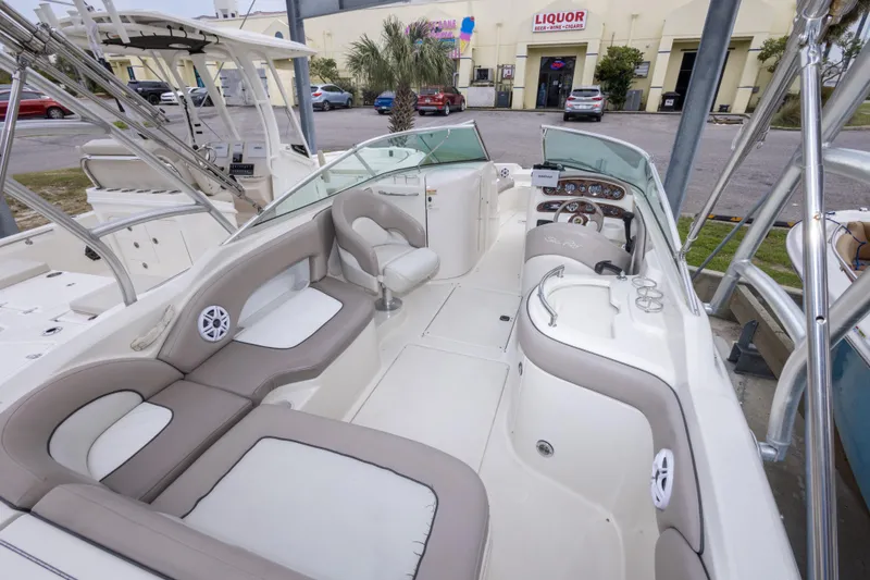 Slide: The Image of 2002 Sea Ray 270 Sundeck boat interior with beige seating and dashboard view. - 13