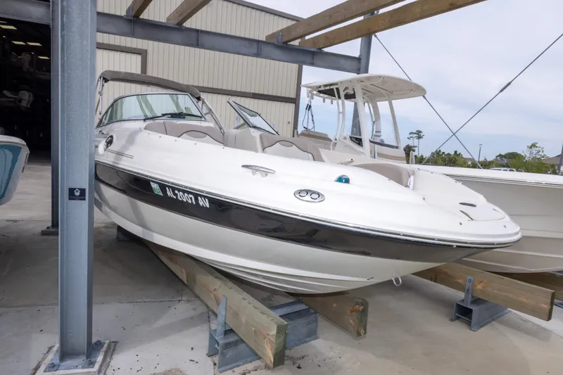 Slide: The Image of 2002 Sea Ray 270 Sundeck boat in storage, white exterior, docked indoors. - 26