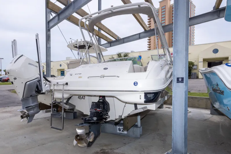 Slide: The Image of 2002 Sea Ray 270 Sundeck boat on a lift, featuring a Mercury outboard motor. - 28