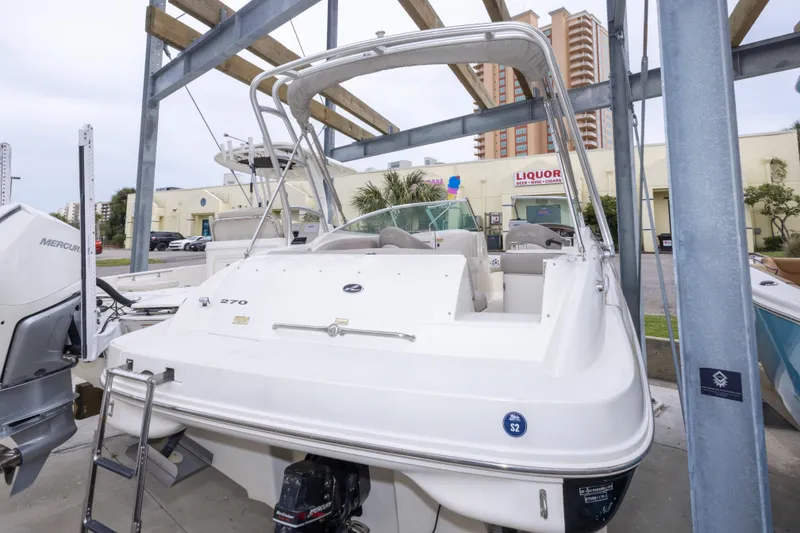 Slide: The Image of 2002 Sea Ray 270 Sundeck boat docked, featuring a Mercury engine and spacious seating. - 31