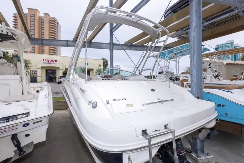 Slide: The Image of 2002 Sea Ray 270 Sundeck boat in storage, with nearby liquor store and high-rise buildings. - 32
