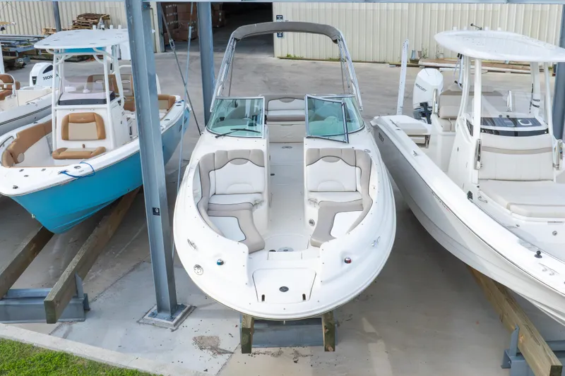 Slide: The Image of 2002 Sea Ray 270 Sundeck boat in storage, flanked by two other boats. - 34