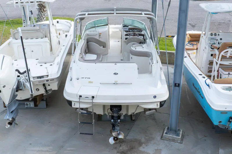 Slide: The Image of 2002 Sea Ray 270 Sundeck boat docked between two other boats. - 36
