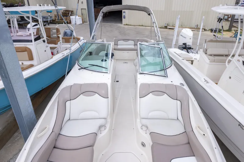 Slide: The Image of 2002 Sea Ray 270 Sundeck boat with spacious seating, docked alongside other boats. - 4