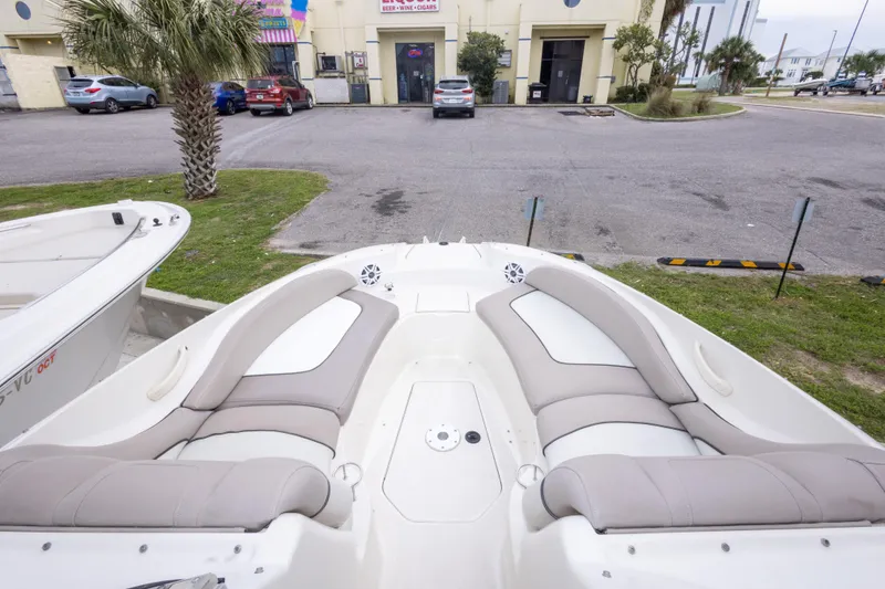 Slide: The Image of 2002 Sea Ray 270 Sundeck boat with spacious seating, parked near a building. - 6