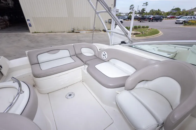 Slide: The Image of 2002 Sea Ray 270 Sundeck interior with beige and white seating, docked outdoors. - 9