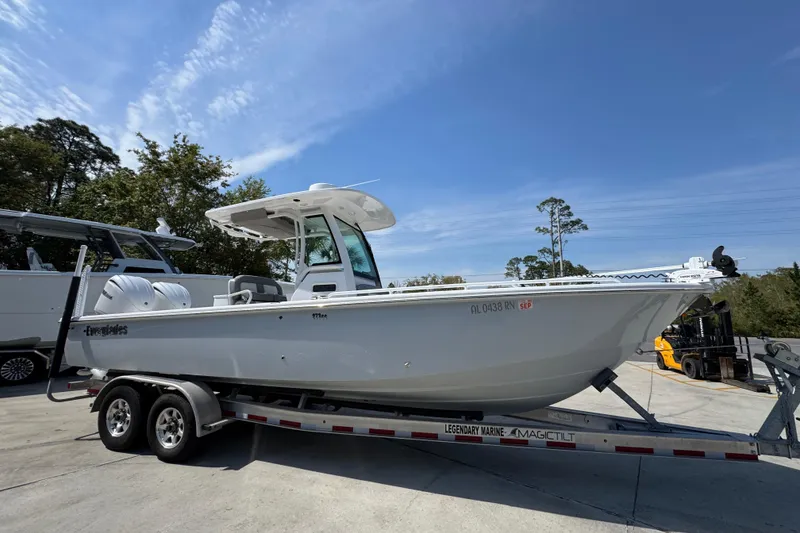 Slide: The Image of 2023 Everglades 273 Center Console boat on trailer, parked outdoors under clear sky. - 10