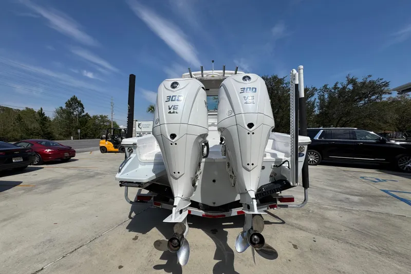 Slide: The Image of 2023 Everglades 273 Center Console boat with twin 300 V6 outboard engines in a parking lot. - 15