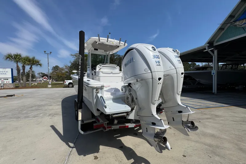 Slide: The Image of 2023 Everglades 273 Center Console boat with dual Yamaha 300 V6 engines, parked outdoors. - 16