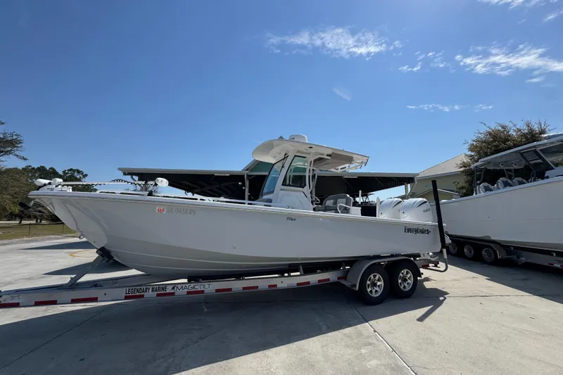Slide: The Image of 2023 Everglades 273 Center Console boat on trailer under clear blue sky. - 2