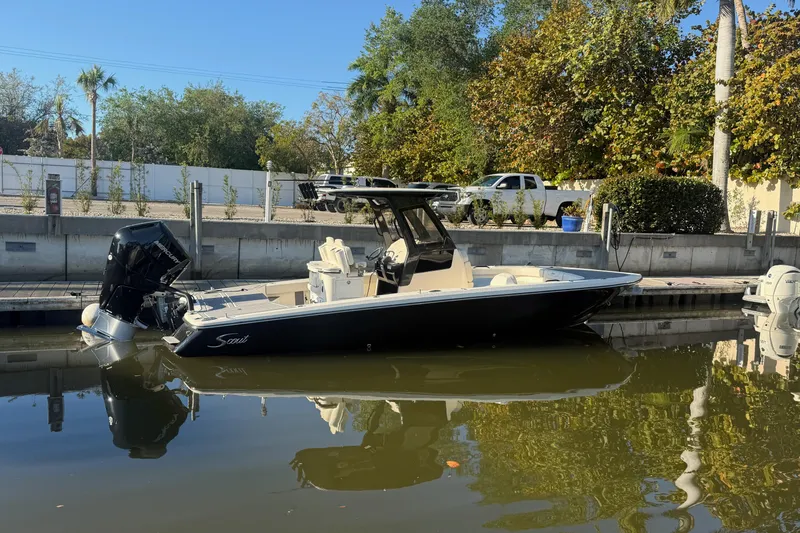 Slide: The Image of 2026 Scout 281 XSS boat docked on calm water, surrounded by lush greenery. - 1