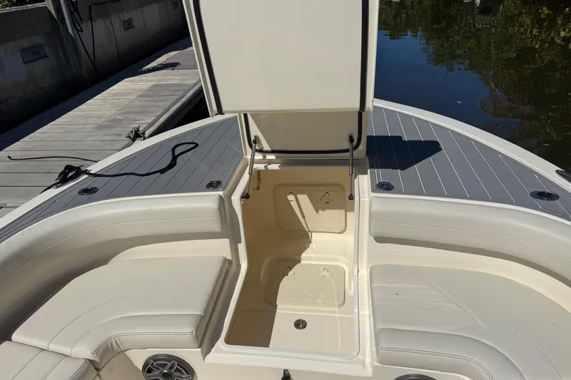 Slide: The Image of 2026 Scout 281 XSS boat interior with open storage compartment and cushioned seating. - 14