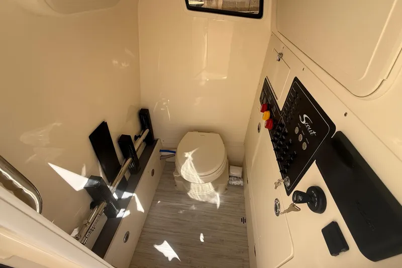 Slide: The Image of Interior of 2026 Scout 281 XSS boat featuring a compact bathroom with control panel. - 16