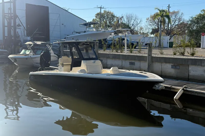 Slide: The Image of 2026 Scout 281 XSS boat docked at marina, reflecting on calm water. - 2