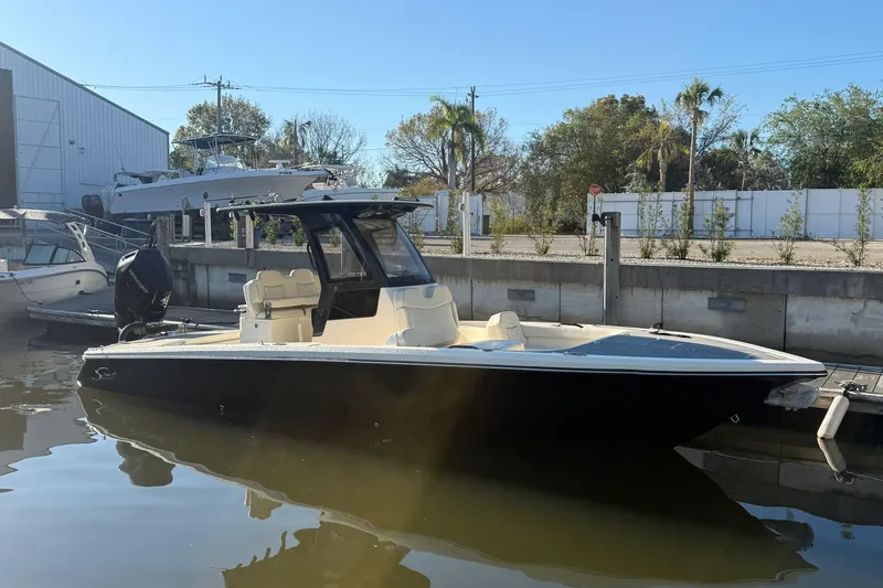 Slide: The Image of 2026 Scout 281 XSS boat docked in a marina under clear blue skies. - 3
