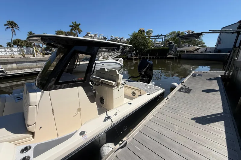 Slide: The Image of 2026 Scout 281 XSS boat docked at marina under clear blue sky. - 5