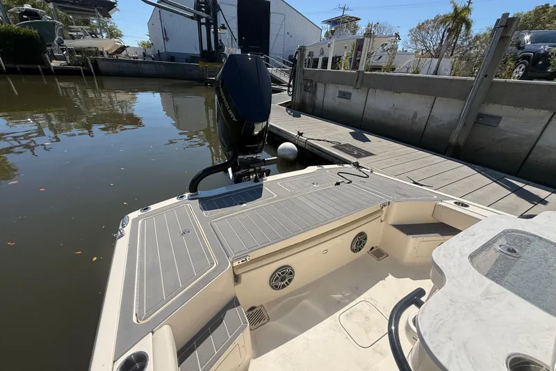 Slide: The Image of 2026 Scout 281 XSS boat docked, featuring sleek deck design and powerful outboard motor. - 6