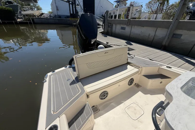 Slide: The Image of 2026 Scout 281 XSS boat interior with seating and motor at dock. - 7
