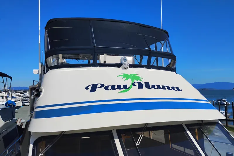 Slide: The Image of 1988 PT 52 AFT Cabin Motor Yacht "Pau Hana" docked at marina under clear blue sky. - 101