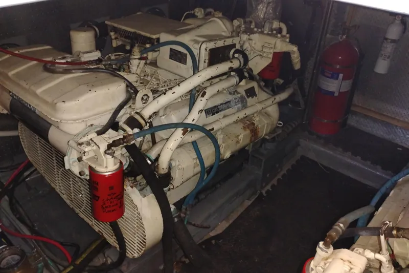 Slide: The Image of Engine room of 1988 PT 52 AFT Cabin Motor Yacht with visible machinery and fire extinguishers. - 105