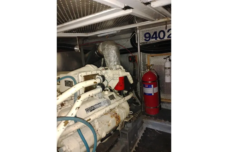 Slide: The Image of Engine room of 1988 PT 52 AFT Cabin Motor Yacht with visible machinery and fire extinguishers. - 106