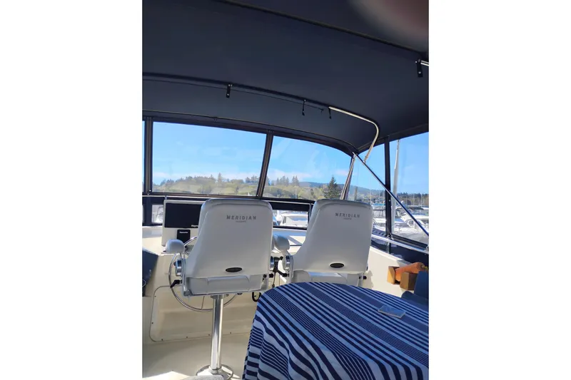 Slide: The Image of 1988 PT 52 AFT Cabin Motor Yacht interior with helm chairs and striped tablecloth. - 11