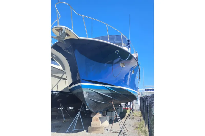 Slide: The Image of 1988 PT 52 AFT Cabin Motor Yacht on dry dock, blue hull, sunny day. - 2