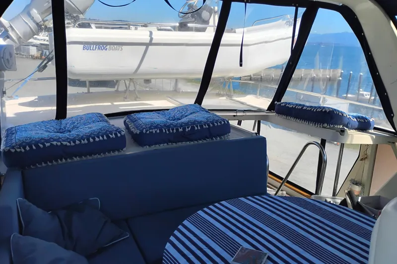Slide: The Image of 1988 PT 52 AFT Cabin Motor Yacht interior with blue cushions and marina view. - 26