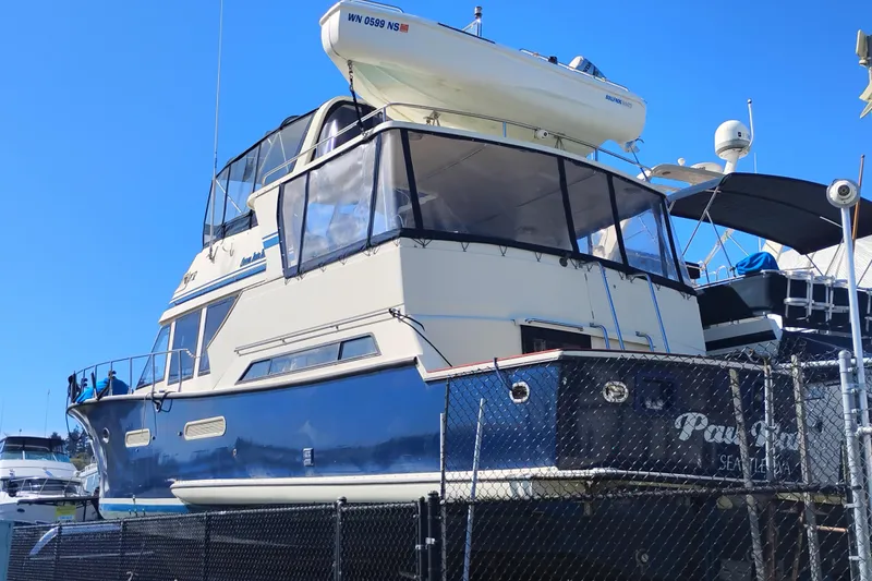 Slide: The Image of 1988 PT 52 AFT Cabin Motor Yacht docked, featuring a sleek design and spacious upper deck. - 3