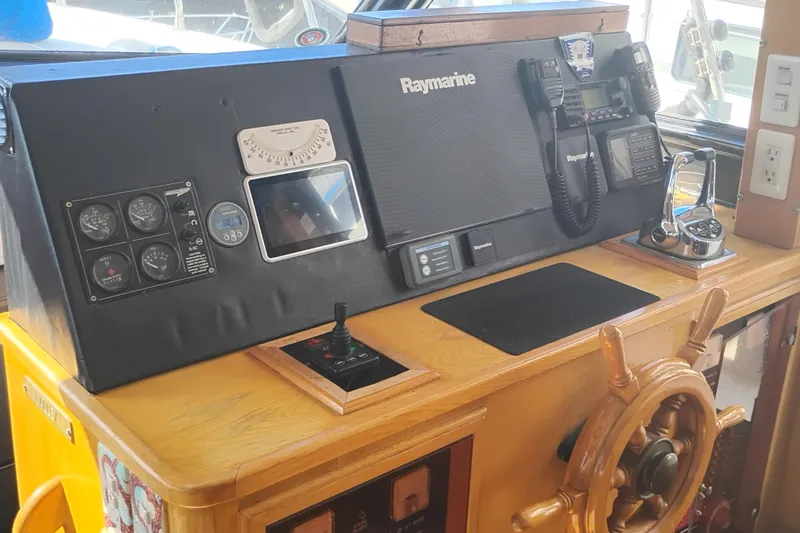 Slide: The Image of Control panel of 1988 PT 52 AFT Cabin Motor Yacht with Raymarine equipment and wooden steering wheel. - 44