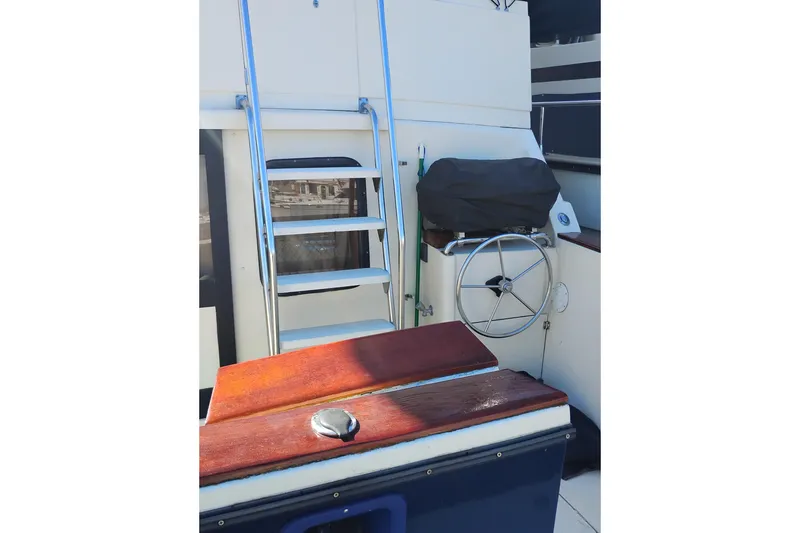 Slide: The Image of 1988 PT 52 AFT Cabin Motor Yacht helm with ladder and wooden accents. - 6