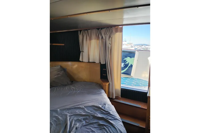 Slide: The Image of 1988 PT 52 AFT Cabin Motor Yacht interior with bed and window view. - 61
