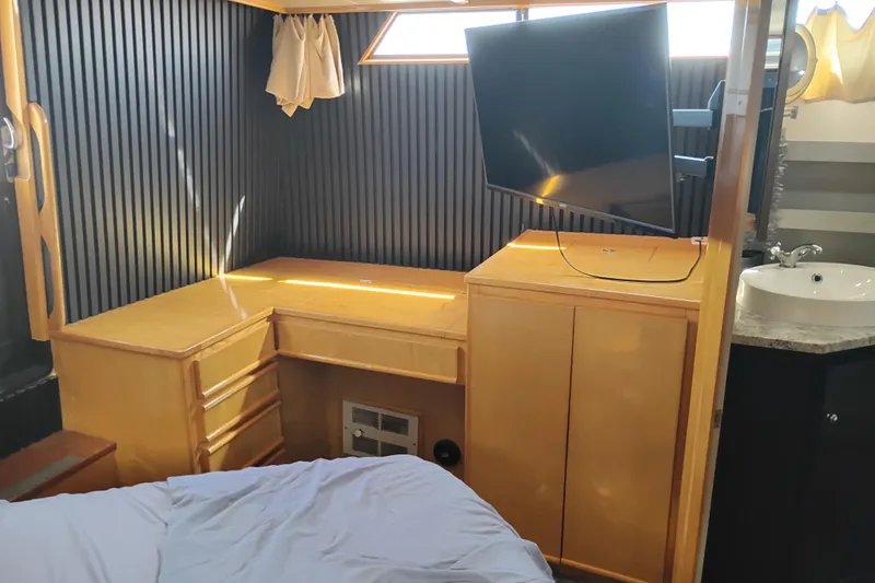 Slide: The Image of 1988 PT 52 AFT Cabin Motor Yacht interior with TV, desk, and sink. - 63