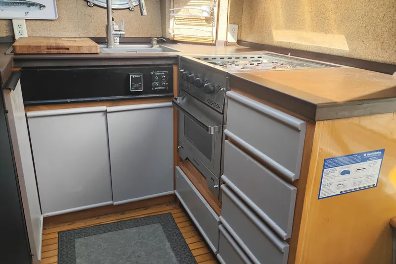 Slide: The Image of 1988 PT 52 AFT Cabin Motor Yacht kitchen with stove, sink, and cabinetry. - 77