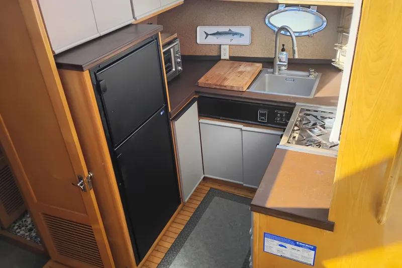 Slide: The Image of Compact kitchen in 1988 PT 52 AFT Cabin Motor Yacht with sink, stove, and fridge. - 78