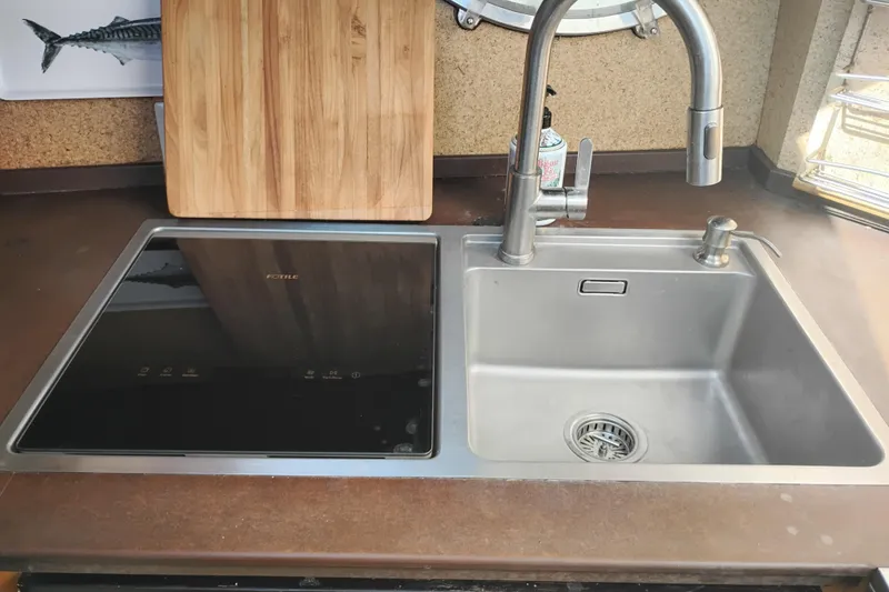 Slide: The Image of Modern kitchen sink and induction cooktop on 1988 PT 52 AFT Cabin Motor Yacht. - 81