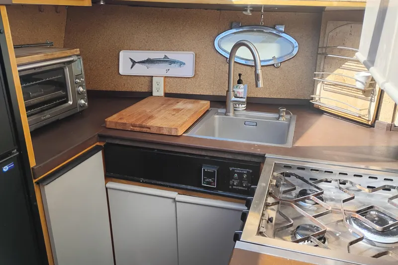 Slide: The Image of Compact kitchen in 1988 PT 52 AFT Cabin Motor Yacht with stove, sink, and toaster oven. - 83