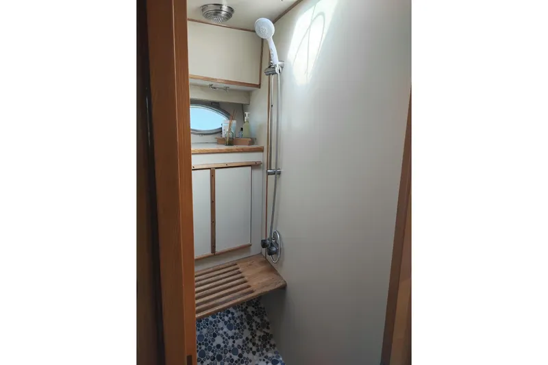 Slide: The Image of Shower area in 1988 PT 52 AFT Cabin Motor Yacht with wooden bench and porthole. - 91