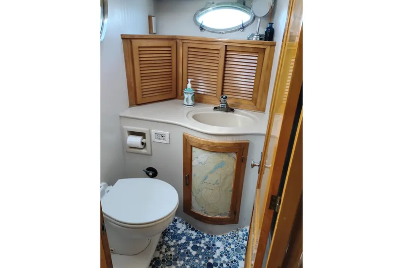 Slide: The Image of 1988 PT 52 AFT Cabin Motor Yacht bathroom with wooden cabinets and nautical decor. - 93