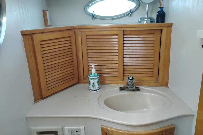 Slide: The Image of 1988 PT 52 AFT Cabin Motor Yacht bathroom with wooden cabinets and sink. - 94