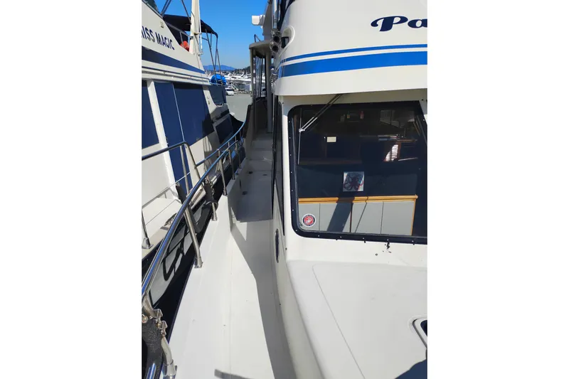 Slide: The Image of 1988 PT 52 AFT Cabin Motor Yacht docked, showcasing side deck and cabin window. - 98