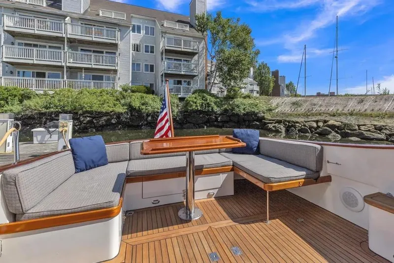 Slide: The Image of Luxury seating area on 2007 Gorbon Custom Downeast 40 yacht, docked near waterfront buildings. - 15